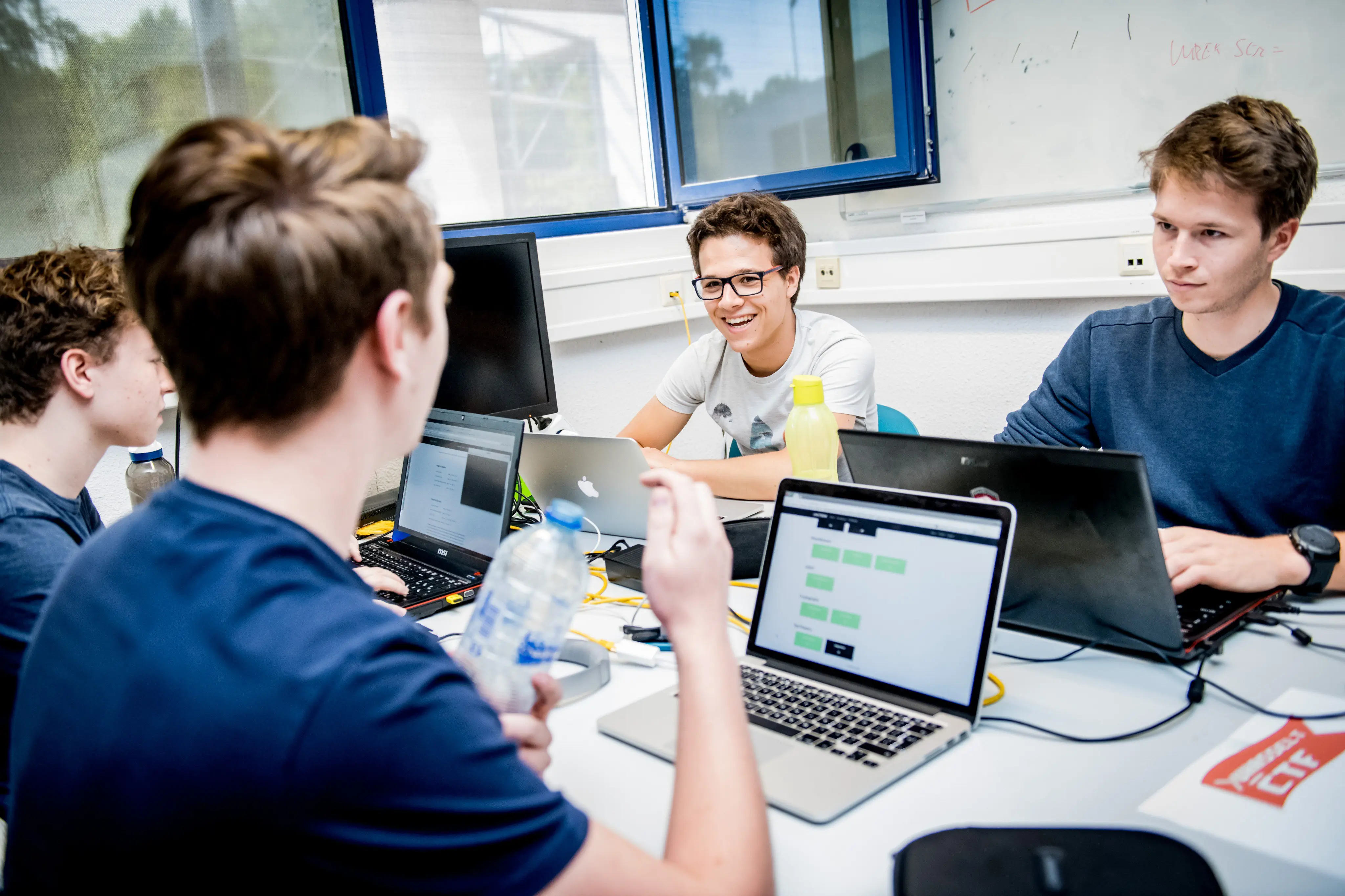 A team of four students are smiling